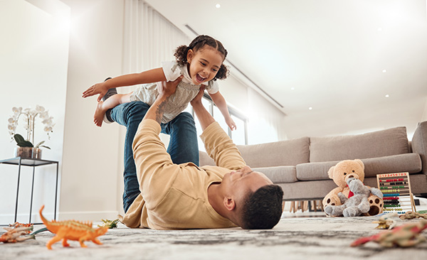 Family with kids and dog playing on floor